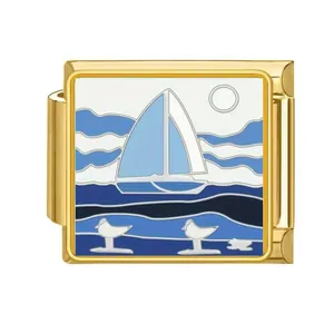 Detalle de un eslabón modular italiano dorado con diseño de velero azul esmaltado
