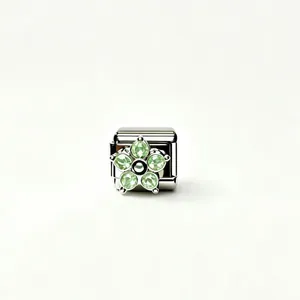 Macro view of polished stainless steel charm with green zircon flower for modular bracelet