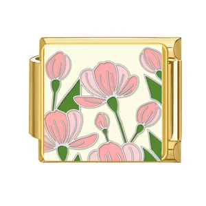 Detail of a gold Italian charm link with a pink flower and green leaf pattern design