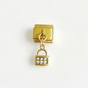 Primo piano di un charm dorato per bracciale modulare con lucchetto di cristallo