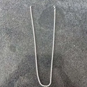Vista detallada de cadena de cuerda de plata de ley 925 de 3 mm en fondo de piedra