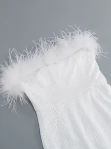 Detalle de primer plano de un vestido blanco de lentejuelas con lujoso adorno de plumas de avestruz