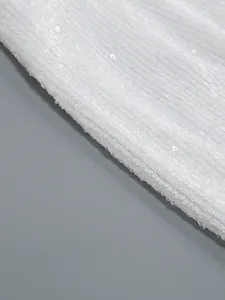Primer plano macro del detalle de tela con lentejuelas blancas de un vestido de lujo