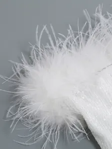 Detalle macro de lentejuelas blancas y plumas de avestruz en un vestido elegante