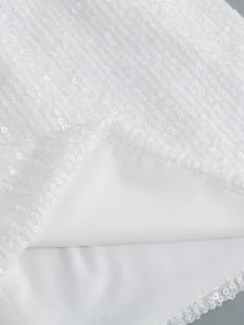 Vista macro de las densas lentejuelas blancas y el forro suave de este elegante vestido