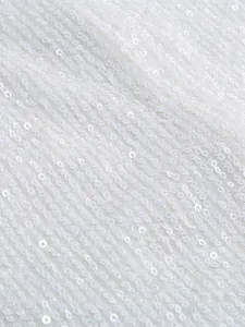 Detalle macro de tela de lentejuelas blancas brillantes para vestidos de fiesta.