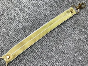 Dettaglio ravvicinato di un cinturino da collo in tessuto giallo con moschettone dorato