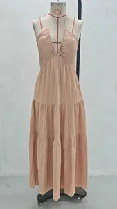 Detailed look at the peach pleated halter-neck maxi dress on a mannequin stand