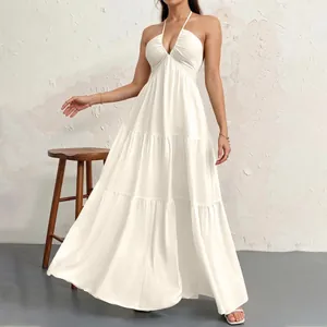 Elegant white halter neck tiered maxi dress featuring deep V-neck and textured fabric