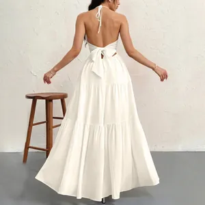 Elegant white halter neck maxi dress featuring a detailed open back with a large bow