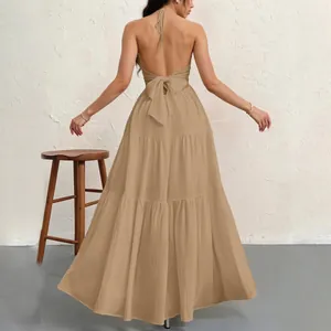 Back view of a chic tan halter maxi dress with an elegant oversized bow tie-back detail.