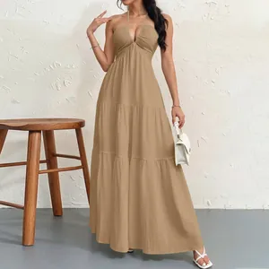 Full length view of elegant khaki halter neck maxi dress featuring a tiered skirt design