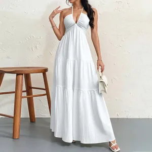 Detailed macro view of white tiered halter maxi dress showing pleated fabric texture.