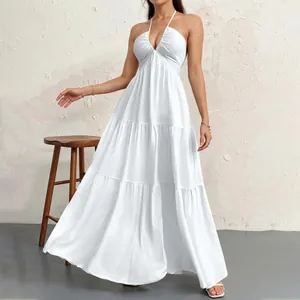 Elegant white halter neck tiered maxi dress shown on a model in a minimal studio setting