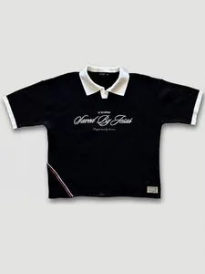 Détail de polo en maille noir avec imprimé blanc Saved By Jesus et col contrasté