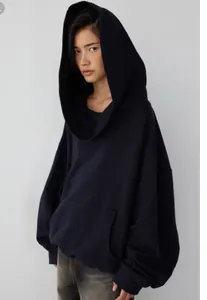 Close-up of an oversized navy hoodie with a large sculptural hood and soft fleece lining