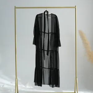 Vue détaillée d'un élégant peignoir long en mousseline noire transparente avec des volants