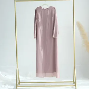 Élégante robe longue en mousseline vieux rose à manches longues sur un support doré chic