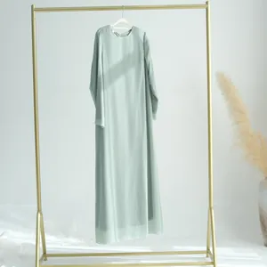 Robe longue élégante en mousseline froissée vert menthe sur un portant doré chic