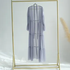 Détail d'une robe longue en mousseline de soie gris lavande sur un portant doré chic