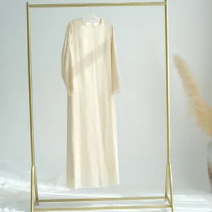 Présentation d'une robe longue élégante en mousseline crème sur un portant à vêtements