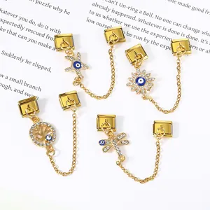 Close-up detail of gold Italian charm links featuring Evil Eye charms and rhinestones