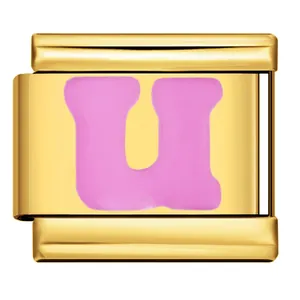 Dettaglio di un charm modulare italiano dorato con lettera U rosa smaltata