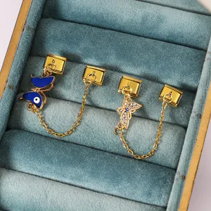 Detailed view of gold Italian charm links with evil eye butterfly and safety chain