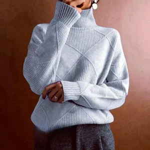 Close-up detail of a light blue high turtleneck sweater with a diamond knit pattern.