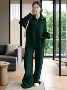 Model wearing a dark green half-zip knitted sweater set in a modern living room