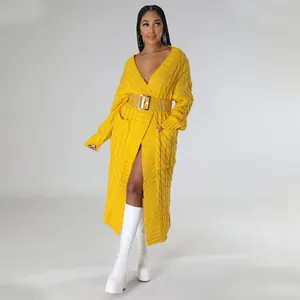 Gedetailleerd overzicht van een lange gele kabelgebreide cardigan gedragen door een model.