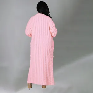 Achteraanzicht van een modieus lang roze vest met een dikke winterse kabeltextuur