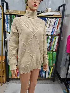 Close-up of a beige turtleneck sweater featuring a classic diamond knit pattern and ribbed cuffs.