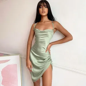 Detail view of elegant sage green satin mini dress featuring chic ruched sides and high slit