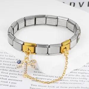 Detailed view of a gold and silver Italian charm bracelet with a dragonfly evil eye charm