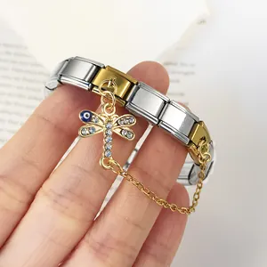 Close-up of two-tone stainless steel modular bracelet with evil eye dragonfly charm