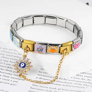 Close-up of Evil Eye sun charm on gold and silver modular Italian stainless steel bracelet.