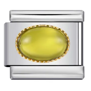 Macro detail of silver Italian charm link with oval yellow gemstone and gold border