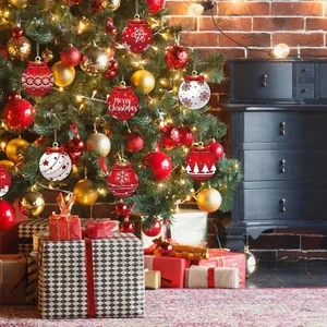 Festive wooden Christmas ornaments displayed on a lit tree with gift boxes.