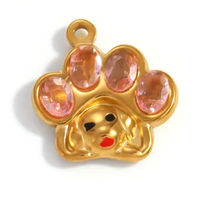 Detalle de un colgante de pata de perro dorado de acero inoxidable con cristales rosas
