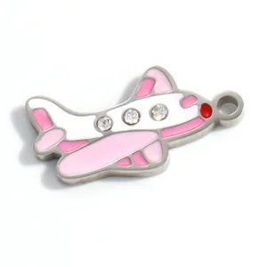 Detalle de primer plano de un colgante de avión en esmalte rosa con pedrería brillante