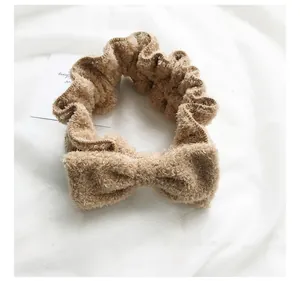 Primo piano di una fascia per capelli con fiocco in peluche beige per il trucco