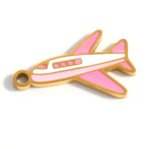 Detalle de un colgante de avión de esmalte rosa y blanco en acero inoxidable dorado.