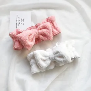 Fasce per capelli a fiocco in morbido pile per lavaggio viso e trucco rosa e bianco.