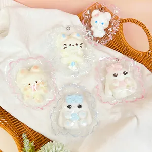 Cinq adorables jouets animaux en silicone dans un emballage à froufrous sur un tissu blanc