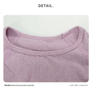 Detailopname van de geribbelde ronde halslijn van een roze fitness top met hoge stretch
