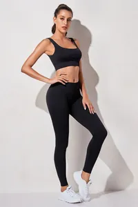 Volledig beeld van een model met zwarte geribbelde sportbeha en hoge taille legging