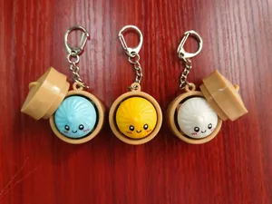 Cute colorful steamed bun emoji keychains with mini steamers for stress relief toys.