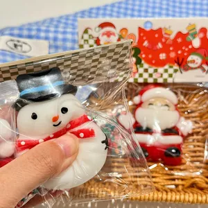 Dettaglio ravvicinato di uno squishy pupazzo di neve natalizio nella sua confezione in plastica.
