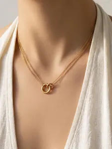 Elegante zweilagige Goldkette mit ineinandergreifenden Ringen am Hals eines Models